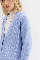 Cardigan celeste de tejido de punto con lentejuelas en el frente, calce relajado y mangas largas. Tejido con terminaciones en punto rib.