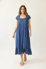 Vestido largo de algodón color azul, de corte holgado con mangas cortas y cuello cuadrado con detalle de cinta. Presenta una hilera de botones en el frente.