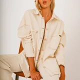 Camisa color crema con botones, de corte holgado y mangas largas.