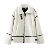 Chaqueta de corderito color blanco con detalles en cuero sintético negro. Tiene cuello solapa, cierre frontal con cremallera y bolsillos laterales.