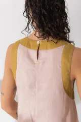 Vestido largo de lino sin mangas, diseñado en color verde oscuro con detalles a contratono en color rosado en el escote y el ruedo. Presenta un corte holgado y relajado.