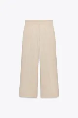 Pantalón negro de tiro alto con bolsillos delanteros, pinzas y corte ancho.