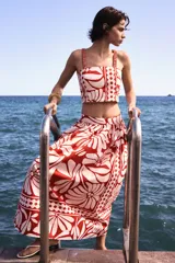 Pollera larga de popelina de algodón con estampado floral en tonos rojo y blanco. Tiene tiro alto, pretina de doble capa y cierre lateral oculto.
