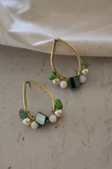 Par de aros colgantes con forma de lágrima, hechos de metal dorado y decorados con cuentas de perlas y piedras de color verde y blanco.