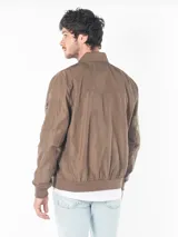 Campera bomber marrón de poliéster, con cierre frontal, puños y dobladillo acanalados, bolsillos laterales con cierre y logo CK bordado en el pecho.