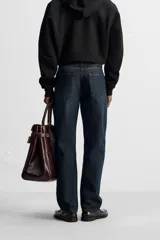 Jeans azul oscuro de corte recto, con largo al tobillo, confeccionados en denim de algodón con efecto lavado. Diseño de cinco bolsillos y cierre frontal con botones.