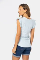 Remera color beige con estampado floral y volados en las mangas.