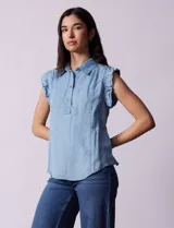 Blusa celeste sin mangas en tencel, marca Zac & Rachel. Cuello con solapa y abertura con botones. Mangas con frunces.