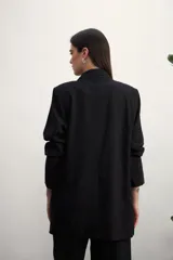 Blazer celeste de lino con solapas de muesca, cierre cruzado con botones, bolsillos delanteros con solapa y corte holgado.