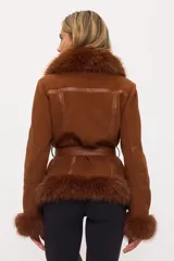 Campera tipo tapado acinturado color marrón, con cuello, puños y bajo de piel sintética. Presenta cierre frontal, detalles de cuero sintético en las mangas y un cinturón anudable del mismo material.