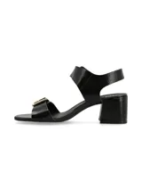 Sandalias negras de charol con hebillas metálicas doradas y taco cuadrado.