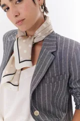 Blazer de lino color crudo con rayas verticales finas en color dorado, de corte recto, con solapas y cierre con un botón.