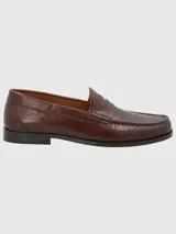 Zapato mocasín de cuero color marrón, con detalle de antifaz y suela de cuero y goma.