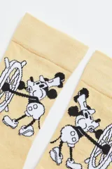 Medias color beige con diseño de Mickey Mouse timoneando un barco.