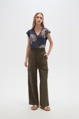 Pantalón cargo color beige de viscosa, tiro alto, corte recto y bolsillos laterales.