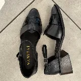 Sandalias de cuero negro marca Vanitas, con puntera fina, diseño combinado de cuero liso y cuero con textura tipo cocodrilo, tira ancha sobre el empeine, tira trasera con hebilla y taco cuadrado de madera.