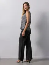 Blusa sin mangas plisada con cuello a la base, marca Zac & Rachel. Tiene una abertura en la espalda con un botón forrado.