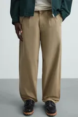 Pantalón color caqui de corte amplio, con pinzas en la cintura, bolsillos laterales y traseros con botón.