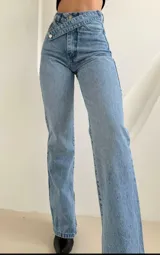 Pantalón de jean celeste de tiro alto, corte recto y cintura cruzada con botón metálico.