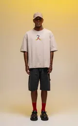 Remera oversize de algodón premium color beige, con cuello redondo y manga corta. Presenta un estampado central de Mickey Mouse en una pose dinámica.