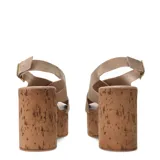 Sandalia de plataforma alta con base de corcho, capellada de tiras cruzadas de gamuza color beige y pulsera ajustable con hebilla metálica dorada.