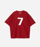 Remera de manga corta estilo polo, color rojo, con cuello y puños en contraste blanco. Presenta un corte oversized con hombros caídos y la palabra "ATHLÈTES" estampada en blanco en el frente. Incluye pequeños gráficos blancos a cada lado del pecho.