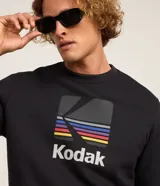 Buzo negro de algodón y poliéster con cuello redondo y mangas largas. Estampado frontal con el logo de Kodak a rayas de colores.