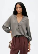 Blusa color marrón con escote en V y mangas 7/8 abullonadas.