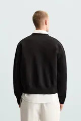 Cárdigan negro de algodón, corte relaxed fit, cuello en V, manga larga, terminaciones en rib y cierre frontal con botones.