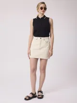 Minifalda de jean color beige, de corte recto y tiro alto.