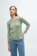 Remera gris de corte ajustado, con cuello redondo y mangas largas. Presenta líneas verticales bordadas en color verde claro y blanco.