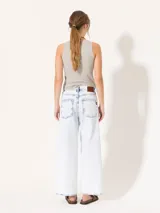 Pantalón de jean celeste con lavado bleach, corte wide leg y largo cropped.