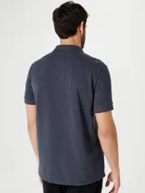 Camiseta tipo polo de manga corta, color azul oscuro, con cuello y tapeta de dos botones.