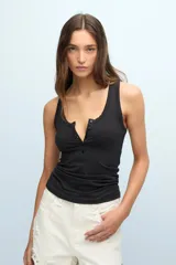 Musculosa negra de algodón pima con lycra, corte ajustado, escote en U, espalda deportiva y cierre frontal con botones.