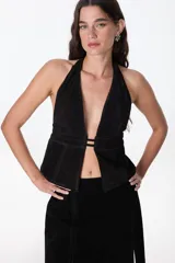 Top halter de cuero color beige, con escote profundo en V y cierre frontal con tiras horizontales.