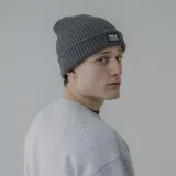 Gorro de lana blanco con etiqueta negra con el logo de la marca Pulau.