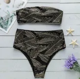 Conjunto de bikini negro con estampado de hojas doradas. Incluye corpiño bandeau y bombacha de tiro alto.