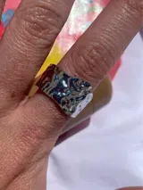 Anillo plateado regulable de acero inoxidable con forma irregular y superficie texturizada.