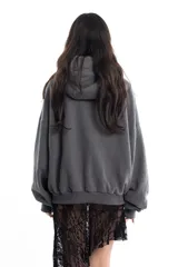 Campera gris de algodón con cierre frontal, capucha y bolsillos tipo canguro. Tiene costuras a la vista, remaches y bordado.