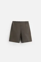 Bermuda regular fit negra confeccionada en tejido de lino. Cintura elástica ajustable con cordón y pliegues frontales. Bolsillos frontales y detalle de bolsillos traseros de plastrón.
