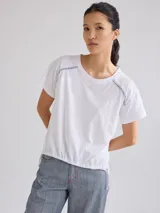 Remera negra de algodón con mangas cortas con detalle de calado y bordado en los hombros y mangas. Corte recto con cintura ajustable con cordón.