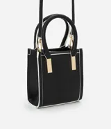 Bolso transversal pequeño tipo bandolera, color negro con detalles en blanco y herrajes dorados. Tiene correa de mano, asa larga desmontable y cierre superior.