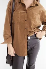 Camisa marrón de pana con corte clásico, cuello camisero, cierre frontal con botones y dos bolsillos de parche en el pecho.