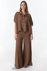 Pantalón ancho de lino color fucsia, tiro alto, con bolsillos traseros y corte amplio que cae recto hasta el suelo.