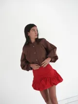 Falda corta estilo 'balloon' o bombacha de vestir, color rojo vibrante, con cintura marcada y volumen en el ruedo.