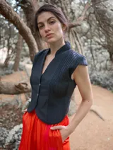 Chaleco negro con cuello mao, sin mangas y cierre frontal con botones.
