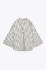 Camisa oversize a rayas verticales color verde y blanco, de cuello solapa y escote pico, con mangas anchas 3/4 terminadas en vuelta y bajo asimétrico.