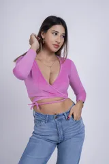 Remera corta gris de punto con escote cruzado y mangas largas.