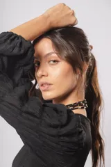 Vestido negro de cuello redondo, con mangas largas tipo globo y terminación elástica, confeccionado en dos telas combinadas.