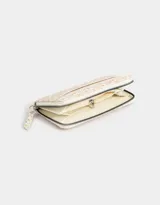 Billetera con cierre, formato fichero, de cuerina color crudo con estampado de flores y cachemir.